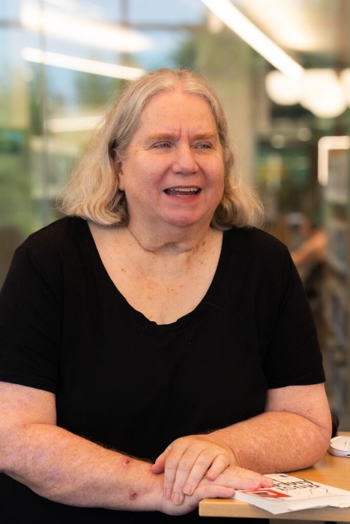 Beth Landon, Reading Partners Coordinator at an Oklahoma City adult learning center, seated and smiling during a literacy session.