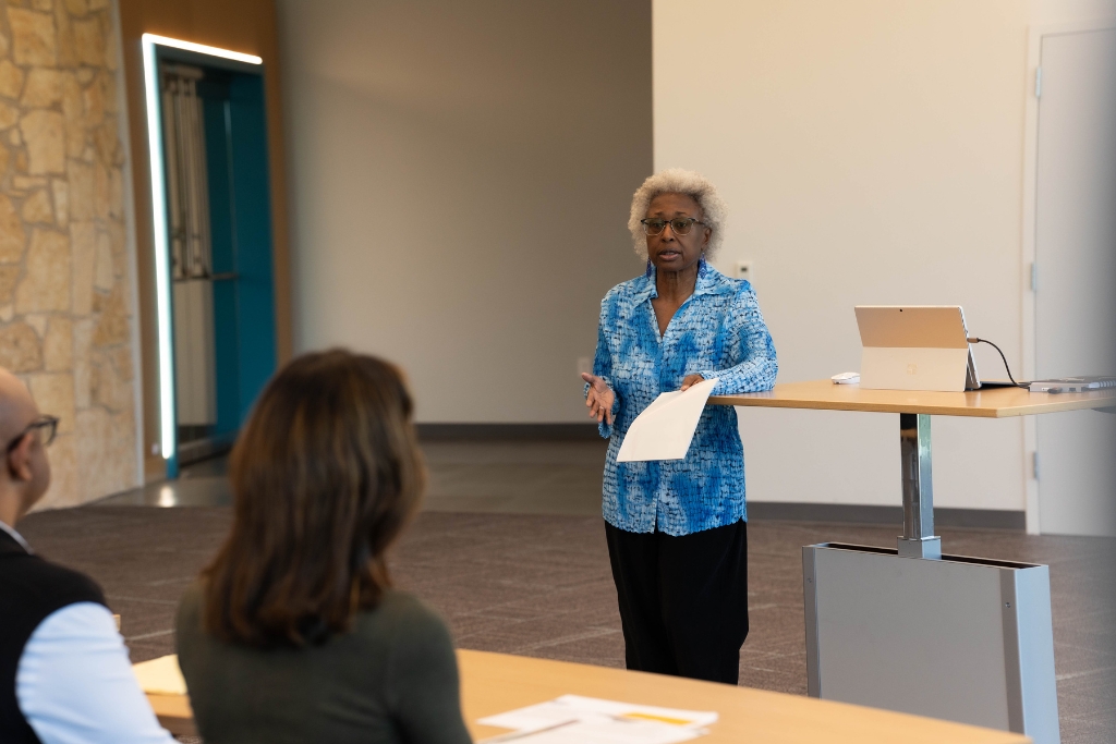Educator giving a presentation to adults during an adult literacy workshop.