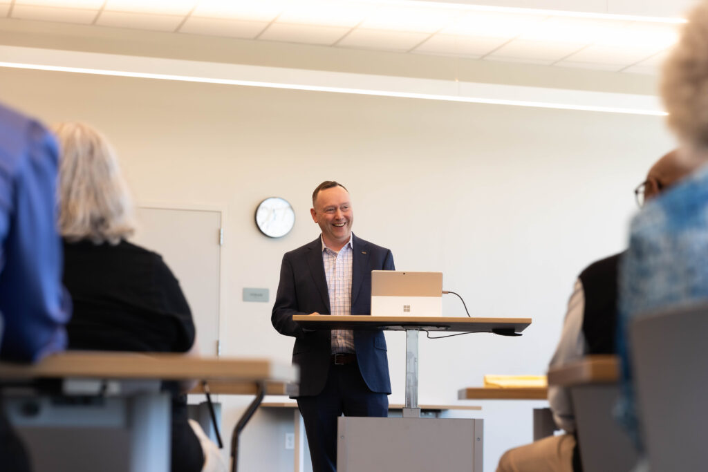 Male presenter delivering an engaging session on adult literacy to a classroom audience.