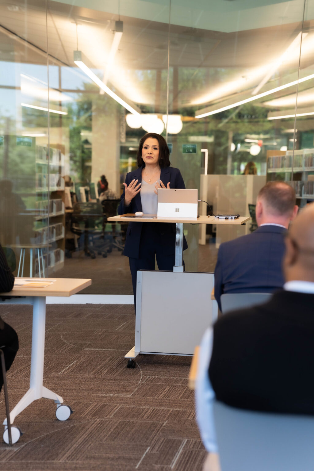 Instructor leading a diverse adult literacy class in a large open learning space.